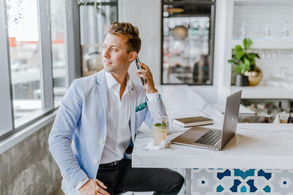 man working remote from home talking on his cell phone